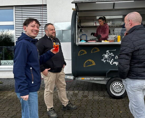 Vor dem Catering Wagen wurde auf das 7. Firmenjubiläum der argvis; angestoßen